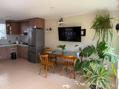 a kitchen with a table and chairs and a refrigerator at Ethan's House - Como en Casa