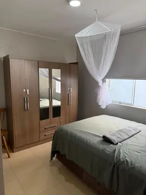 a bedroom with a bed and wooden cabinets and a window at Ethan's House - Como en Casa