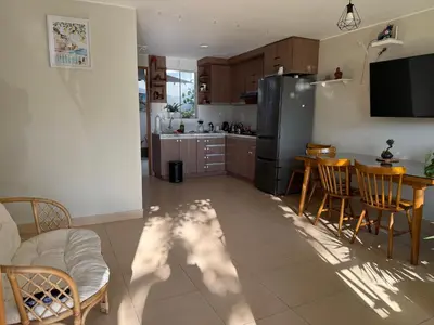 a kitchen and dining room with a table and a refrigerator at Ethan's House - Como en Casa