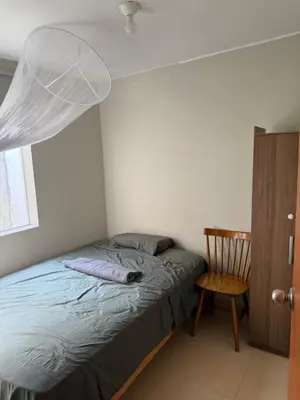 a bedroom with a bed and a wooden chair at Ethan's House - Como en Casa