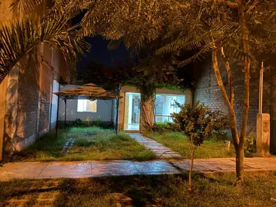 a house with a palm tree and an umbrella at Ethan's House - Como en Casa