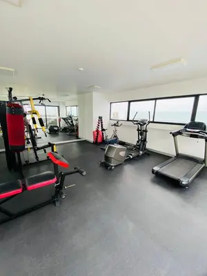 a gym with several treadmills and exercise bikes at San Miguel Apartment Vista Mar in Lima