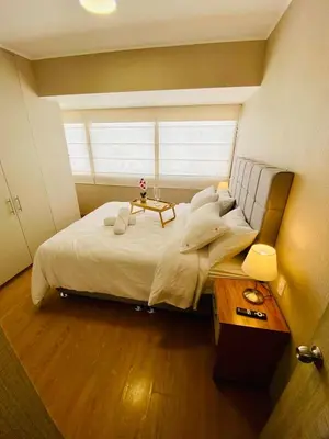 a bedroom with a large bed with a table on it at San Miguel Apartment Vista Mar in Lima