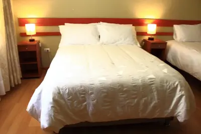 a large white bed in a room with two lamps at Hotel Villarma in Alis