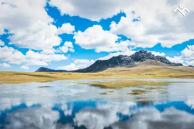 a mountain reflection in a body of water at Hotel Villarma in Alis