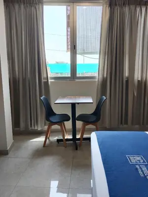 a room with a table and two chairs and a window at Luxotel Business Chincha in Chincha Alta