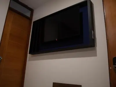 a flat screen tv on the wall of a room at Luxotel Business Chincha in Chincha Alta