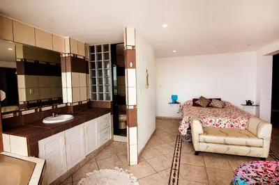 a bathroom with a bed and a sink in a room at Casa Las Brisas de Villa frente al mar in Lima