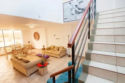 a living room with a staircase in a house at Casa Las Brisas de Villa frente al mar in Lima