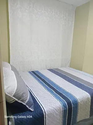 a bed with a blue and white striped blanket at Hospedaje TITANIC in Huancayo