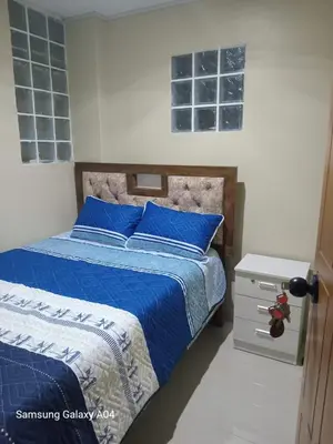 a bedroom with a blue bed with blue pillows at Hospedaje TITANIC in Huancayo