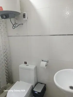 a white bathroom with a toilet and a sink at Hospedaje TITANIC in Huancayo