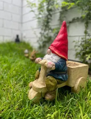 a gnome sitting on top of a wooden box in the grass at Casa con piscina, terraza y parrilla en Ica in Ica