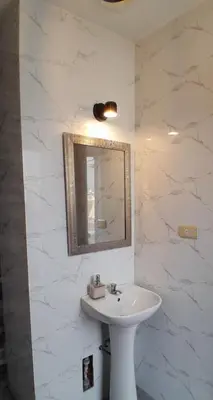 a white bathroom with a sink and a mirror at Casa con piscina, terraza y parrilla en Ica in Ica