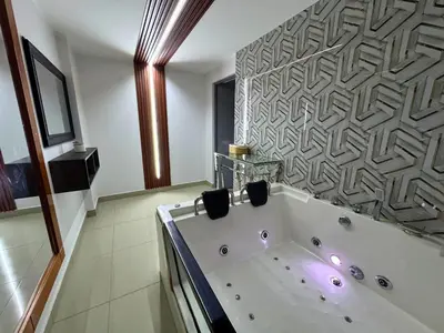 a large bath tub in a bathroom with a wall at City Tower Hotel in Lima