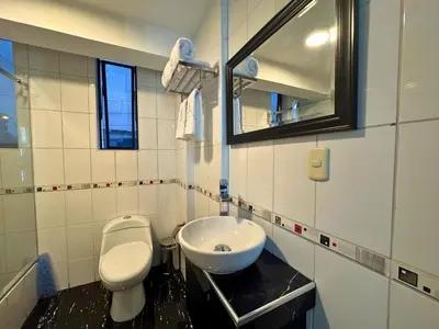 a bathroom with a white toilet and a sink at City Tower Hotel in Lima