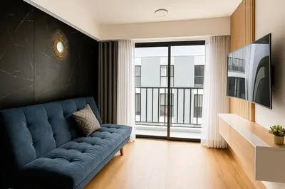 a living room with a blue couch and a large window at Moderno Departamento con Terraza, cerca a la Playa in Lima