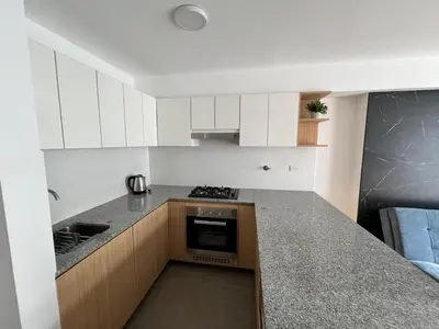 a kitchen with white cabinets and a counter top at Moderno Departamento con Terraza, cerca a la Playa in Lima