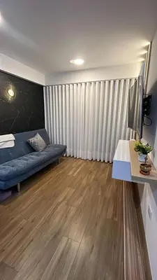 a living room with a blue couch and wooden floors at Moderno Departamento con Terraza, cerca a la Playa in Lima