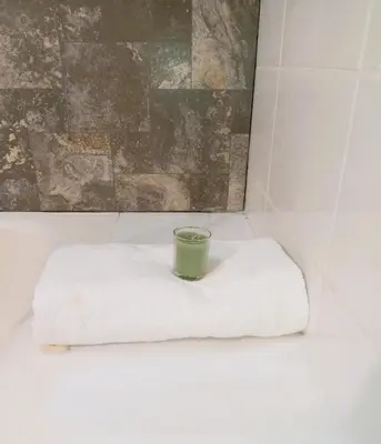 a green candle sitting on top of a white towel at Loft steps away from Larcomar for urban explorers in Lima