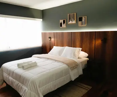 a bedroom with a large bed with white sheets at Loft steps away from Larcomar for urban explorers in Lima