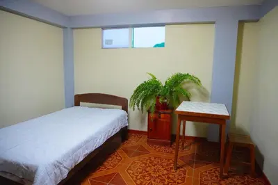 a bedroom with a bed and a potted plant at Cómodo alojamiento con jardín y baño privado-Echarati
