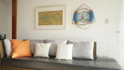 a couch with pillows and a clock on a wall at Condominio Maradentro - Casas de playa en exclusivo balneareo de chepeconde in Los Leones
