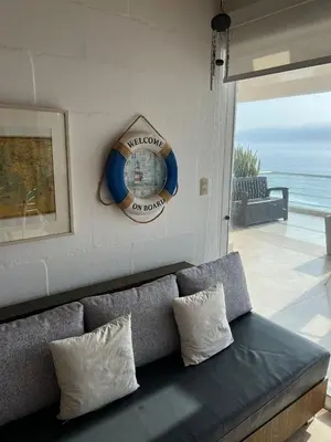 a couch in a living room with a clock on the wall at Condominio Maradentro - Casas de playa en exclusivo balneareo de chepeconde in Los Leones