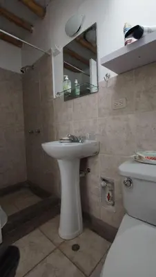 a bathroom with a sink and a toilet and a mirror at Condominio Maradentro - Casas de playa en exclusivo balneareo de chepeconde in Los Leones