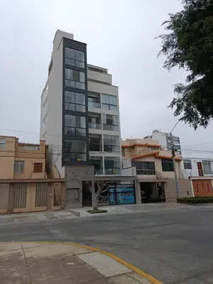 a tall building in a city with a parking lot at HK5 Bed And Breakfast Apartment in Lima