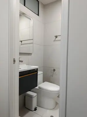 a white bathroom with a toilet and a sink at HK5 Bed And Breakfast Apartment in Lima