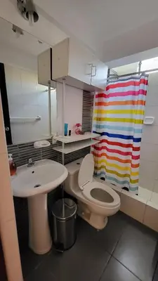 a bathroom with a sink and a toilet and a rainbow shower curtain at Completo, Moderno y Confortable Departamento in Lima