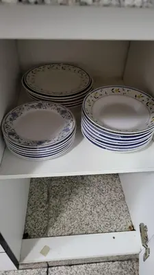 four plates are sitting on a shelf in a cabinet at Completo, Moderno y Confortable Departamento in Lima
