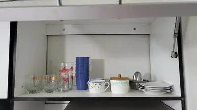 a shelf with dishes and other items on it at Completo, Moderno y Confortable Departamento in Lima
