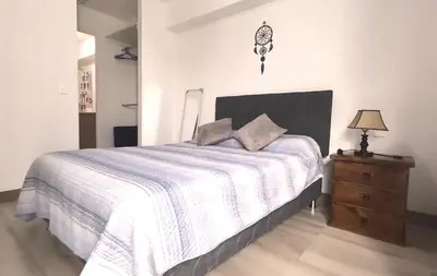 a bedroom with a bed and a dresser with a lamp at Beautiful and quiet aparment, near to Larcomar, cliff, Kennedy Park in Lima
