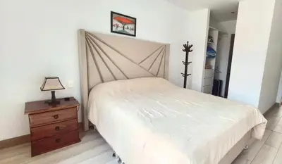 a bedroom with a bed and a dresser with a lamp at Beautiful and quiet aparment, near to Larcomar, cliff, Kennedy Park in Lima
