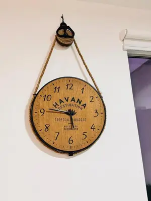 a wooden clock hanging on a wall at A unos pasos de la Arena in Puerto Viejo