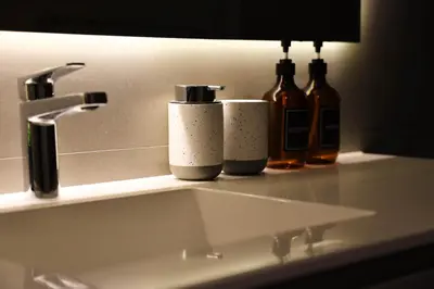 a bathroom sink with three bottles on a counter at Estancia de lujo en Miraflores Entre Marriott y Pullman in Lima
