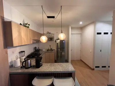 a kitchen with a counter with two stools in it at Tempo Moderno Departamento in San Antonio