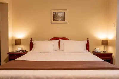 a bedroom with a large bed with two night stands at El Marquez Huancayo in Huancayo