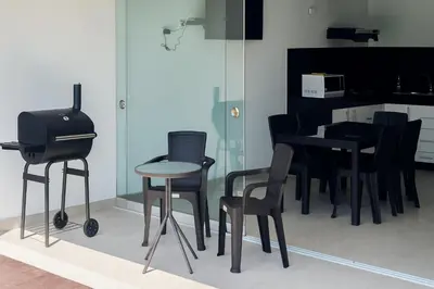 a kitchen with black chairs and a table and a grill at Departamento con Jacuzzi privado y acceso directo al mar in Asia