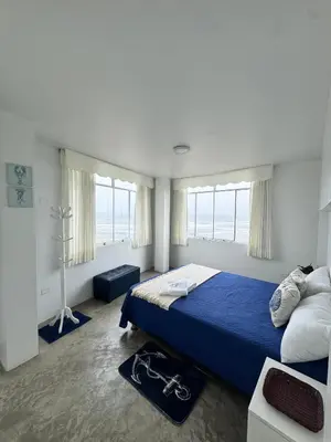 a bedroom with a blue bed and a large window at Departamento en Chancay con Vista al Mar y cerca al Megapuerto