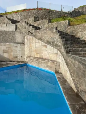 a swimming pool with stone stairs and blue water at Departamento en Chancay con Vista al Mar y cerca al Megapuerto