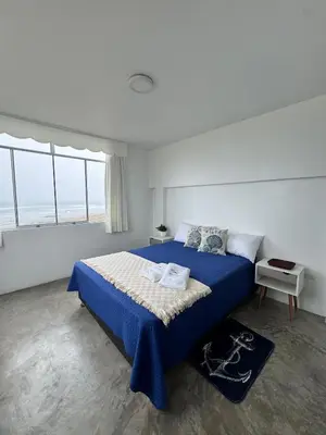 a bedroom with a blue bed with a blue blanket at Departamento en Chancay con Vista al Mar y cerca al Megapuerto