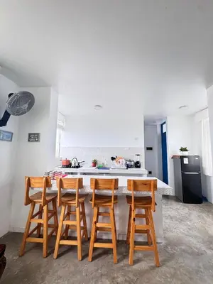 a kitchen with a counter with four wooden bar stools at Departamento en Chancay con Vista al Mar y cerca al Megapuerto