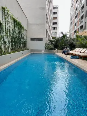 a large blue swimming pool in a building at Depa moderno y ejecutivo en estreno, cerca de San Isidro y Miraflores - nómada in Lima