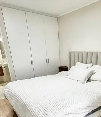 a bedroom with a white bed and white cabinets at Depa moderno y ejecutivo en estreno, cerca de San Isidro y Miraflores - nómada in Lima