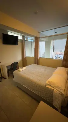 a bedroom with a bed and a desk and a television at Hotel Rodilla in Ayacucho