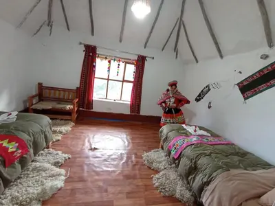 a room with three beds and a person standing in a room at hotel turismo vivencial pallay lliclla in Urubamba
