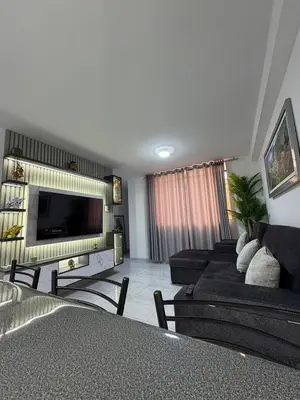 a living room with a couch and a tv at Mini Departamento in Lima